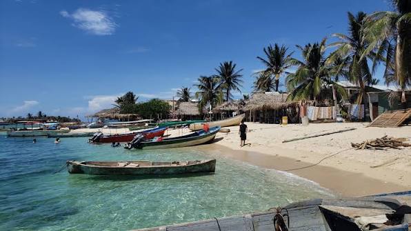 Turquoise Caribbean water and tropical cay representing a Cayos Cochinos day trip